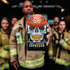 A firefighter holding up the Fire Department Coffee Skull Crushing Espresso 12 ounce bag, surrounded by other firefighters in the background.